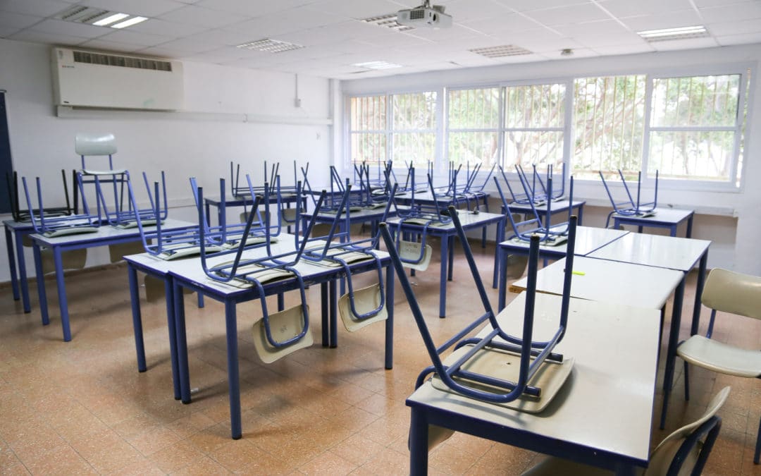 Empty classroom with chairs stacked on desks