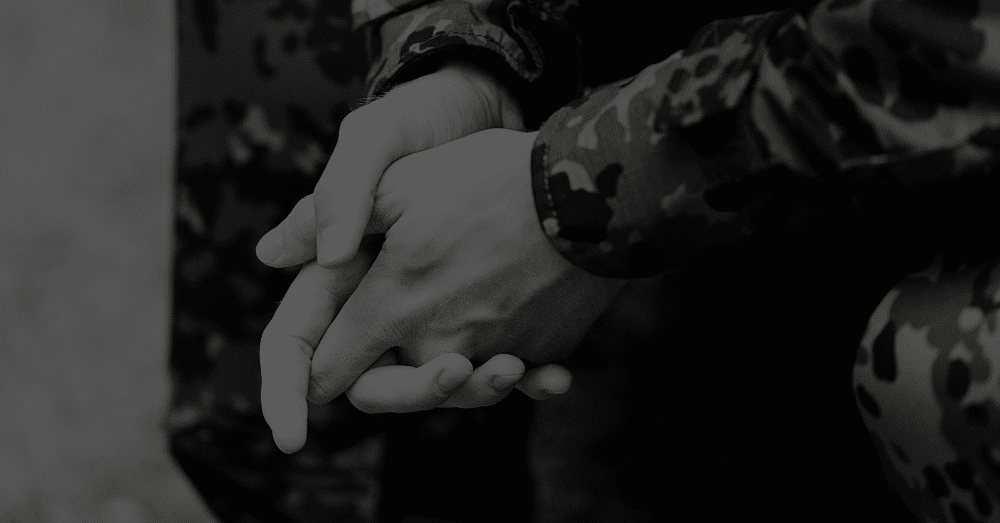 A military man in uniform holding his hands together