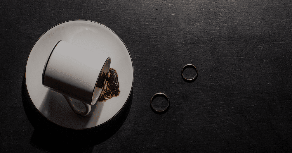 Wedding rings on table with spilt cup of coffee